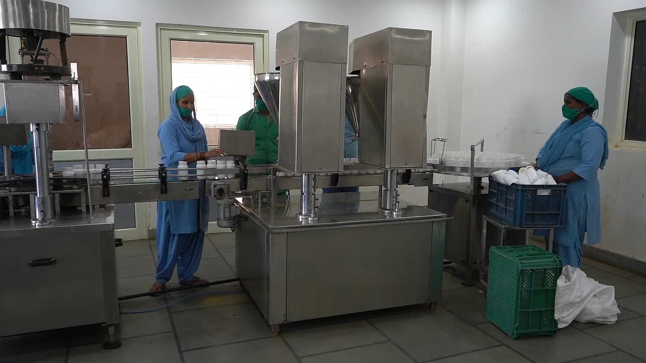 Operators running the bottle filling line on the manufacturing floor